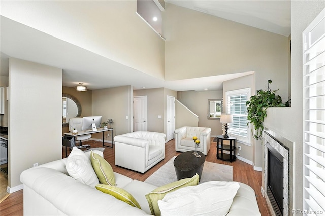 2567 Cutters Cir Unit 101, Castle Rock, CO 80108 - living area featuring wood finished floors, a tiled fireplace, and high vaulted ceiling
