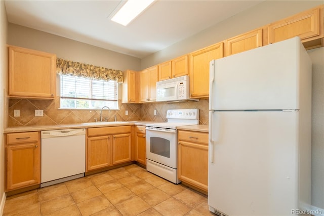 kitchen featuring white appliances, light brown cabinets, a sink, and light countertops