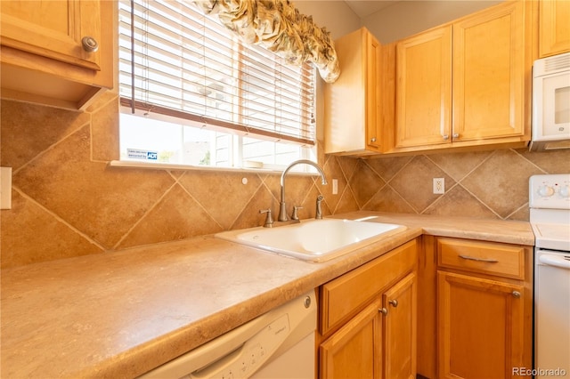 kitchen featuring white appliances, backsplash, a sink, and light countertops