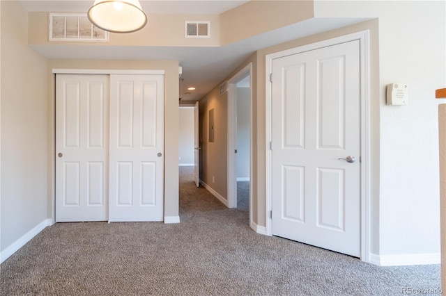 unfurnished bedroom featuring visible vents, carpet, baseboards, and a closet