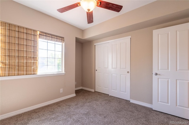 unfurnished bedroom featuring baseboards, ceiling fan, carpet, and a closet