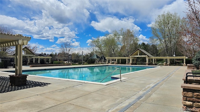 pool with a patio area and a pergola