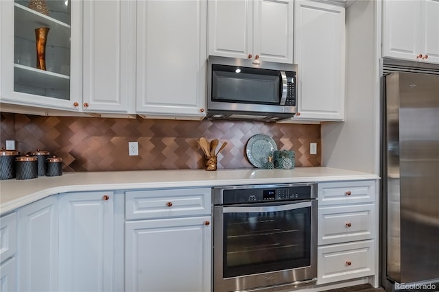 123 Blue Stem St, Brighton, CO 80601 - kitchen featuring appliances with stainless steel finishes, white cabinetry, light countertops, and glass insert cabinets