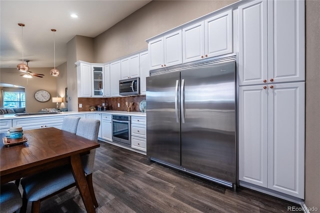 123 Blue Stem St, Brighton, CO 80601 - kitchen featuring stainless steel appliances, dark wood-style floors, white cabinetry, hanging light fixtures, and light countertops