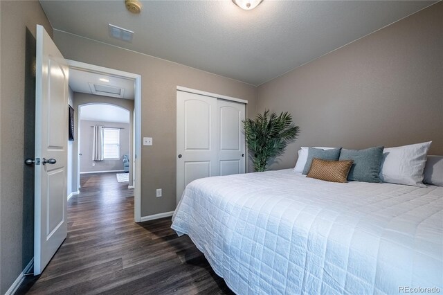 123 Blue Stem St, Brighton, CO 80601 - bedroom with dark wood-style flooring, arched walkways, and a closet