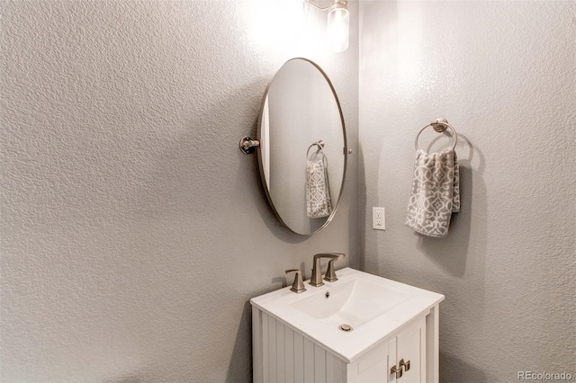 bathroom with vanity and a textured wall