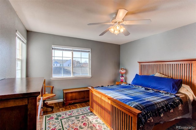 bedroom featuring wood finished floors, baseboards, and ceiling fan