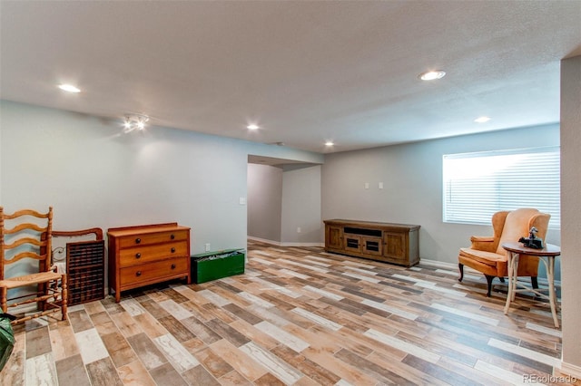 living area with recessed lighting, light wood-type flooring, and baseboards