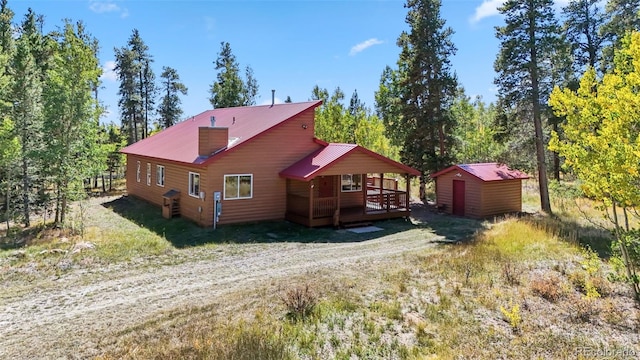 back of house featuring a storage shed and a deck