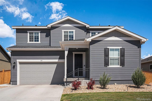 view of front of property with fence, an attached garage, and driveway