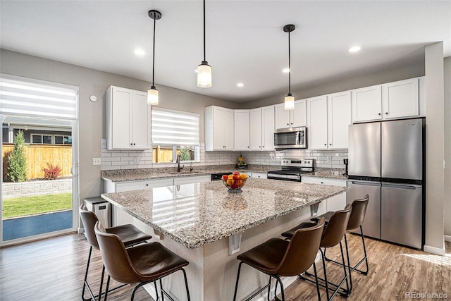kitchen with backsplash, stainless steel appliances, and light wood finished floors