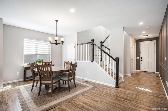 dining area with baseboards, recessed lighting, a notable chandelier, wood finished floors, and stairs
