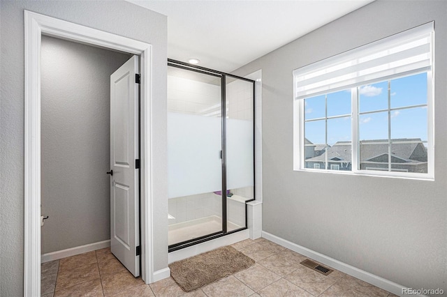 bathroom featuring a shower stall, visible vents, tile patterned floors, and baseboards