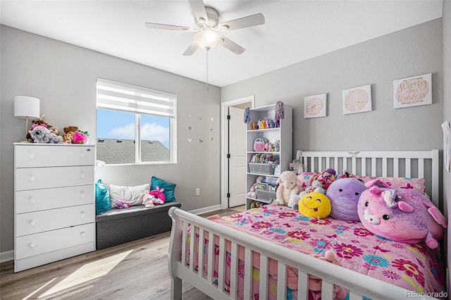 bedroom with ceiling fan, baseboards, and wood finished floors