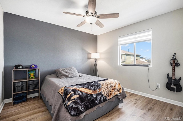 bedroom with baseboards, wood finished floors, and ceiling fan