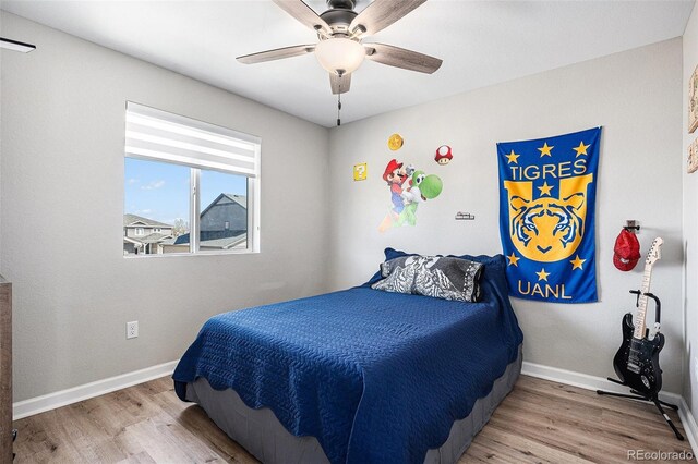 bedroom featuring wood finished floors, baseboards, and ceiling fan