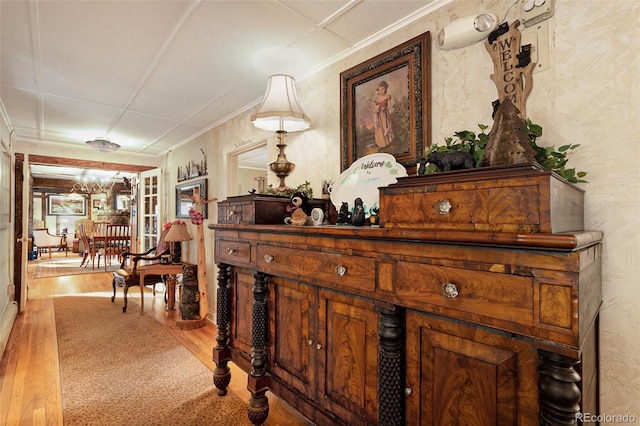 hallway featuring ornamental molding and wood-type flooring