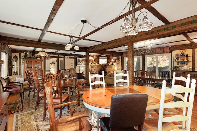 dining area with beam ceiling, hardwood / wood-style flooring, and a chandelier