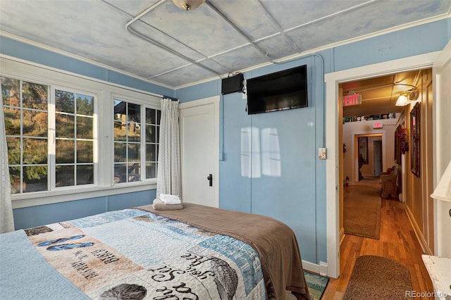 bedroom featuring hardwood / wood-style floors and crown molding