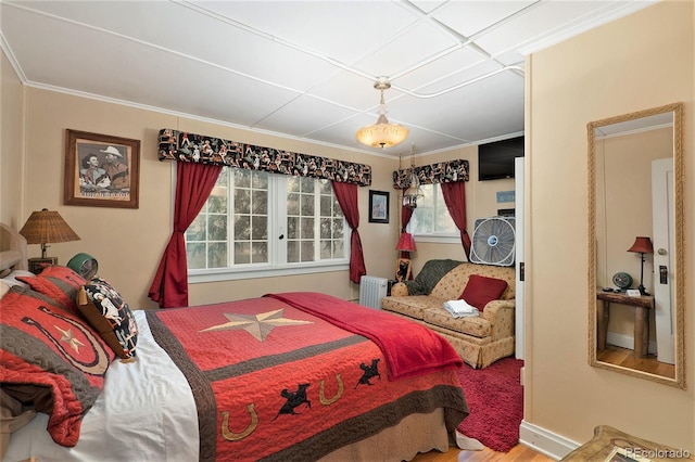 bedroom with hardwood / wood-style flooring, ornamental molding, and radiator heating unit