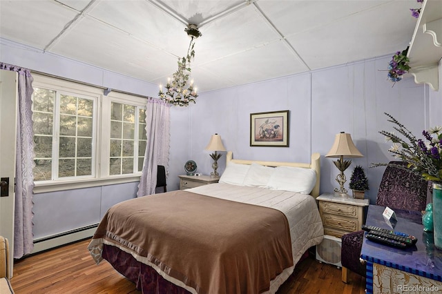 27425 Spruce Ln, Evergreen, CO 80439 - bedroom with a baseboard radiator, wood finished floors, a chandelier, and a decorative wall
