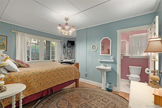 bedroom with ornamental molding, hardwood / wood-style flooring, a chandelier, and sink