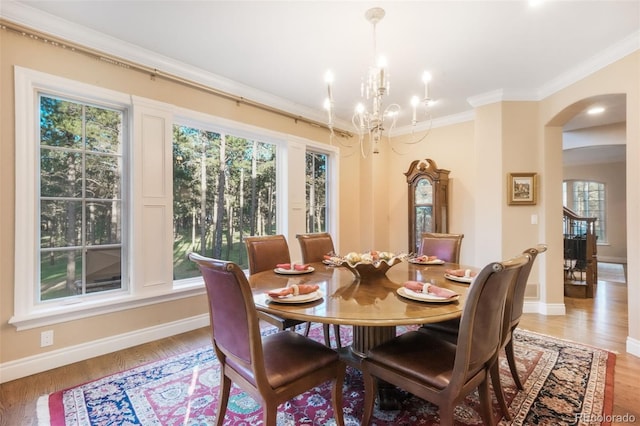 16092 Waving Branch Way, Colorado Springs, CO 80908 - dining area with arched walkways, a chandelier, ornamental molding, plenty of natural light, and baseboards