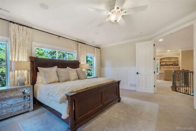 16092 Waving Branch Way, Colorado Springs, CO 80908 - bedroom with wainscoting, light carpet, ornamental molding, ceiling fan, and a decorative wall