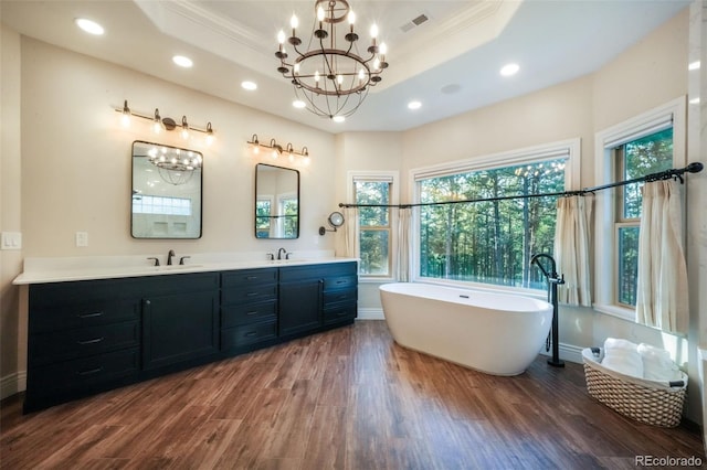 16092 Waving Branch Way, Colorado Springs, CO 80908 - full bathroom with wood finished floors, recessed lighting, a raised ceiling, a freestanding bath, and a chandelier