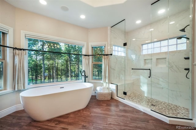 16092 Waving Branch Way, Colorado Springs, CO 80908 - bathroom featuring a freestanding bath, a marble finish shower, recessed lighting, wood finished floors, and baseboards