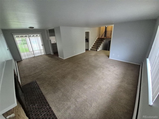 387 Tucson St, Aurora, CO 80011 - unfurnished living room featuring stairs, carpet floors, and baseboards