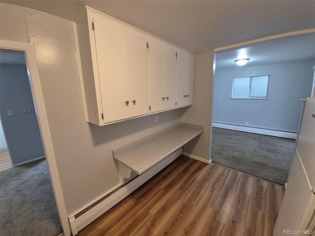 387 Tucson St, Aurora, CO 80011 - interior space featuring a baseboard radiator, dark wood-type flooring, baseboards, and dark carpet