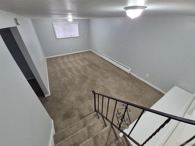 387 Tucson St, Aurora, CO 80011 - basement featuring a baseboard radiator, carpet floors, baseboards, and stairway
