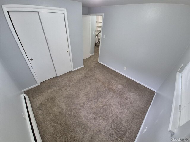 387 Tucson St, Aurora, CO 80011 - unfurnished bedroom with carpet, a baseboard radiator, a closet, and baseboards