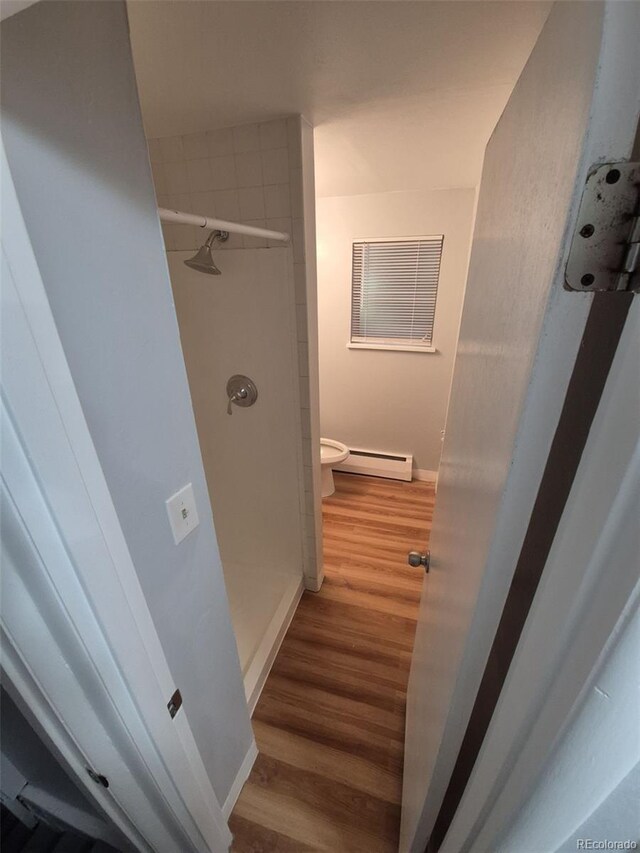 387 Tucson St, Aurora, CO 80011 - hall featuring a baseboard radiator, wood finished floors, and baseboards