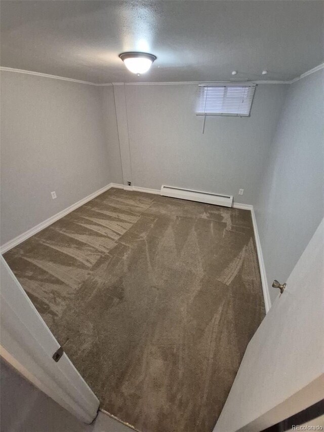 387 Tucson St, Aurora, CO 80011 - below grade area featuring a baseboard heating unit, carpet floors, baseboards, and crown molding