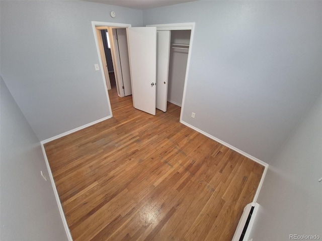387 Tucson St, Aurora, CO 80011 - unfurnished bedroom with light wood-type flooring, baseboards, and a closet