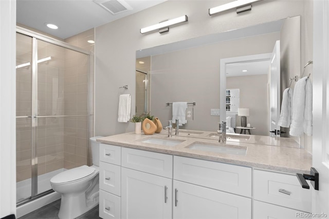 bathroom featuring vanity, toilet, and a shower with shower door