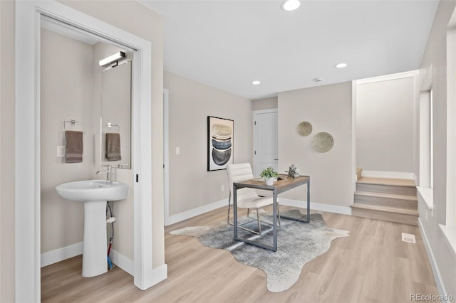 interior space featuring recessed lighting, baseboards, stairs, and light wood-style floors