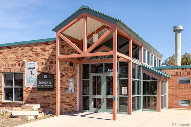 exterior space with brick siding and french doors