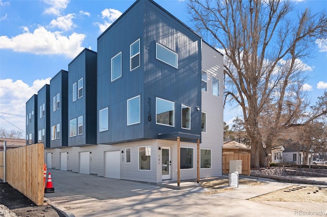 view of front facade featuring fence, an attached garage, and concrete driveway