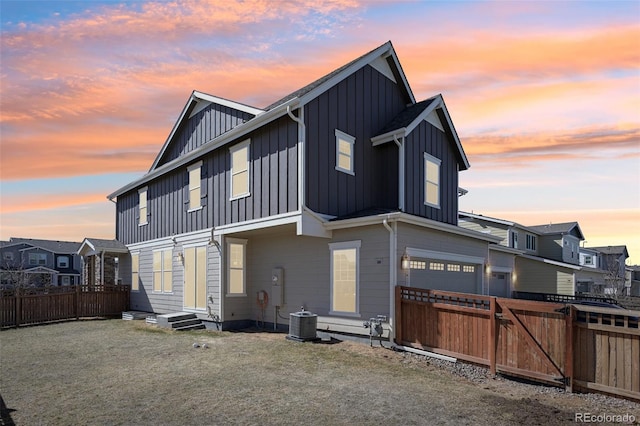 exterior space featuring entry steps, an attached garage, fence, central air condition unit, and board and batten siding