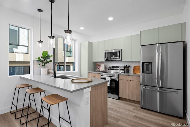 kitchen featuring hanging light fixtures, sink, stainless steel appliances, and a wealth of natural light