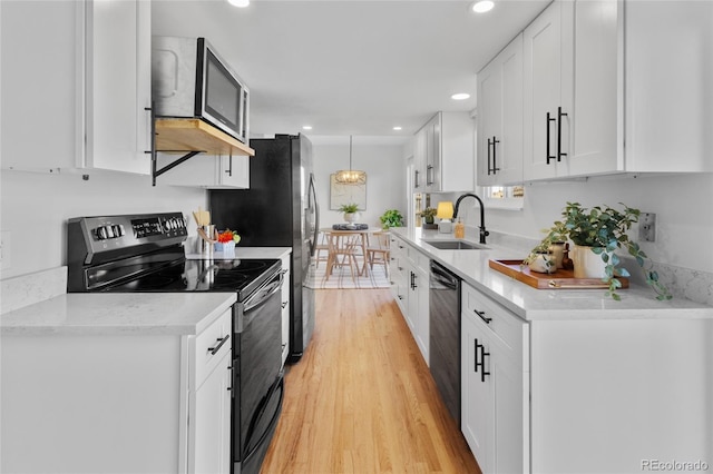 4650 S Idalia St, Aurora, CO 80015 - kitchen with electric range, a sink, dishwashing machine, white cabinetry, and light wood-type flooring