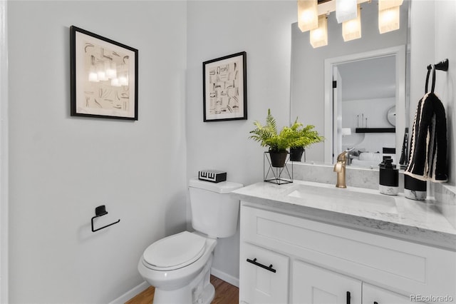 4650 S Idalia St, Aurora, CO 80015 - half bath with toilet, vanity, wood finished floors, and baseboards