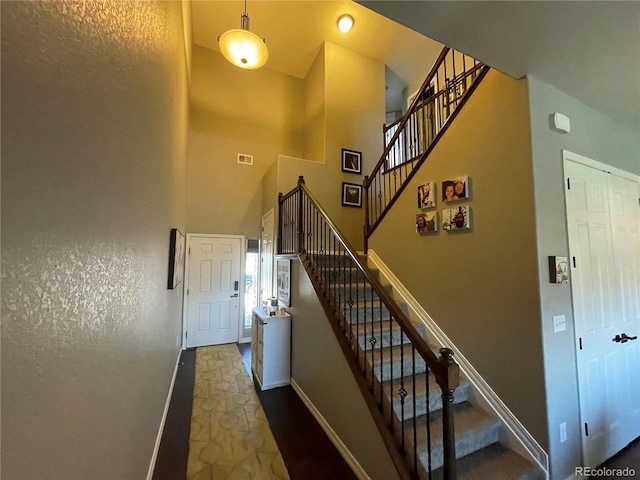 stairs featuring a towering ceiling