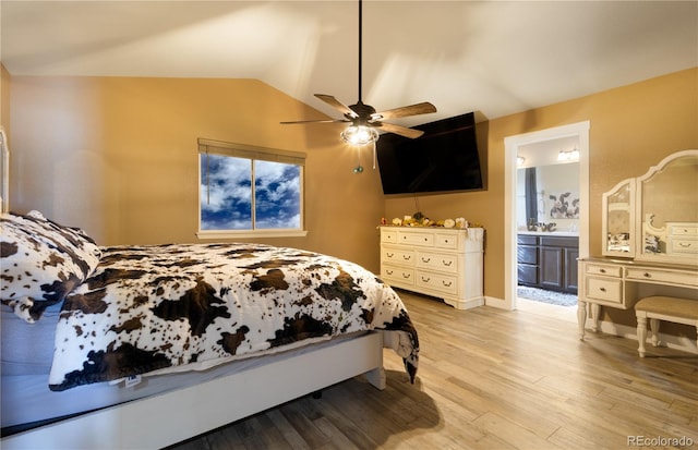 bedroom with ceiling fan, lofted ceiling, ensuite bathroom, and light hardwood / wood-style flooring