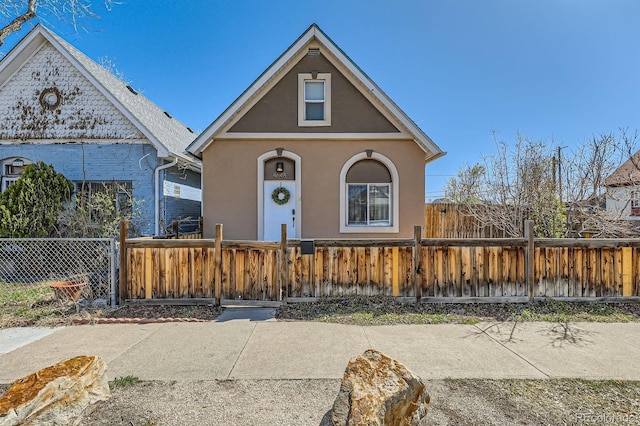 view of front of home featuring stucco siding and a fenced front yard