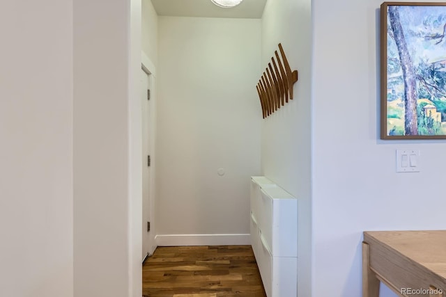 hall with baseboards and wood finished floors