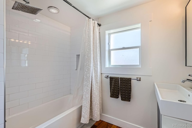 bathroom featuring baseboards, shower / bath combination with curtain, wood finished floors, and vanity